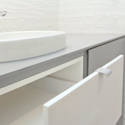 Laundry stand for washing machine topped with grey solid surface, with solid surface drawers and doors / fabricator: Gforma