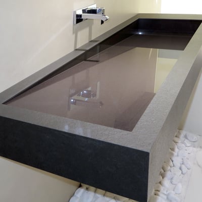 Long angled washbasin with drainage along one side in Neolith sintered stone for a business centre wc