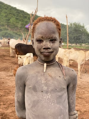 дети в племени Мундари помогают взрослым ухаживать за коровами
