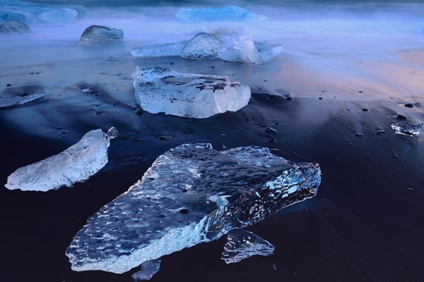 Eisbrocken des Breidamerkurjökull, angeschwemmt an den schwarzen Lavasandstrand der Küste vor Jökulsarlon