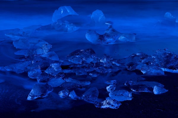 Eisbrocken des Breidamerkurjökull, angeschwemmt an den schwarzen Lavasandstrand der Küste vor Jökulsarlon; hier zur blauen Stunde