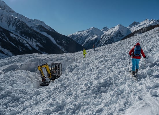 Die Zufahrtsstrasse  wird geräumt. Von der Schneeschleuder gleich links vom Bagger sind nur ein paar Pixel zu sehen bei min. 6-8 Meter Schnee