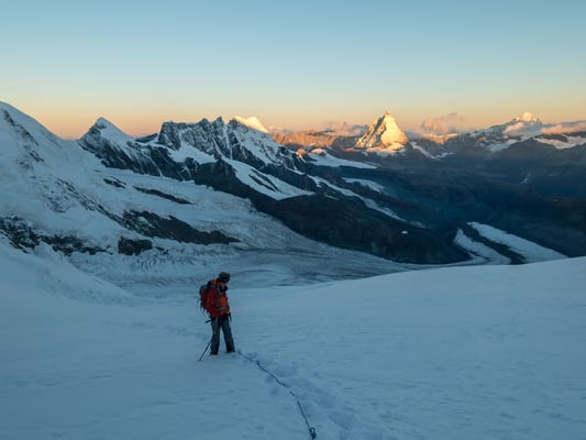 Zurückblicken lohnt sich, die aufgehende Sonne färbt die Walliser Trabanten golden ein