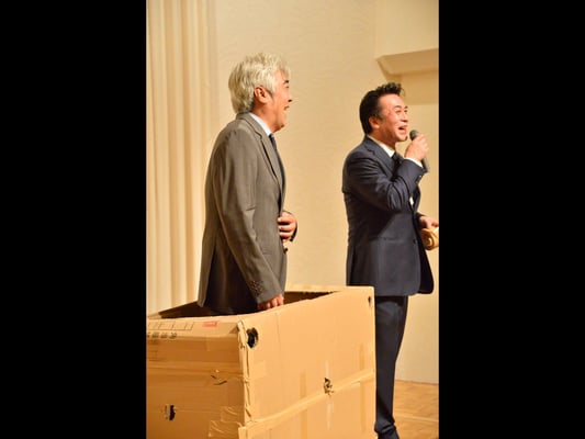 Mr. Takashi Takizawa in a suit goes into the box