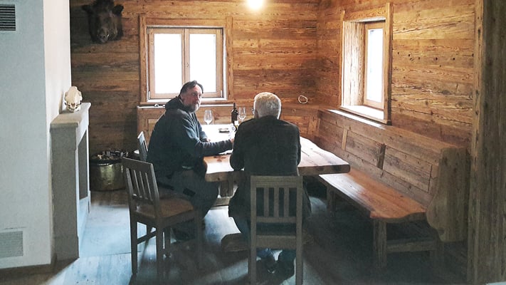 Die Jagdstube mit urigem Tisch, Sesseln und einer gemütlichen Sitzbank.