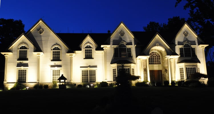 The distinctive architectural elements of this home's facade are accentuated in the evening with the "grazing" technique. Upper Saddle River, NJ
