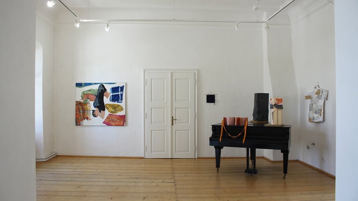 Ausstellung "Menschenufer" Kleiner Raum: "Mittagsschlaf", links über Klavier: "Kleine Abendmappe", am Klavier: "Blusenleporello", "Arbeitshosenmappe" und "Kragenbär", Rechts vom Klavier: "Zigarettenpapierhemd" aus "Legal Drugs"