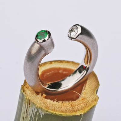 Offener Platinring mit einem Brillanten und einem Tsavorit