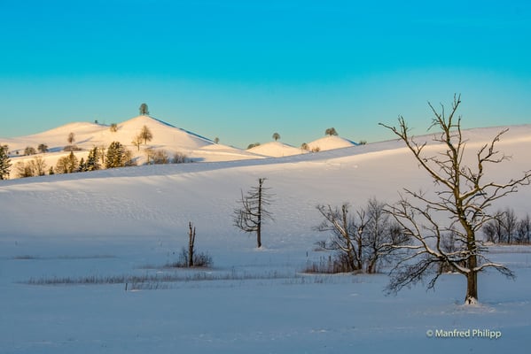 Aufgehende Sonne beleuchtet die Moränenhügel