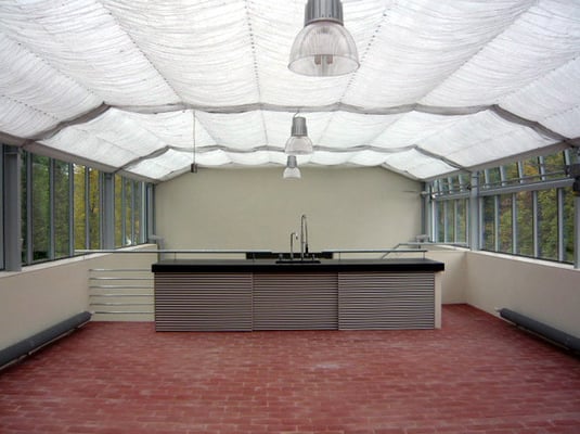 Sommerküche im Glashaus: Gefärbter Beton/Alulamellen/Klinkerziegel - Foto © Knauer Architekten