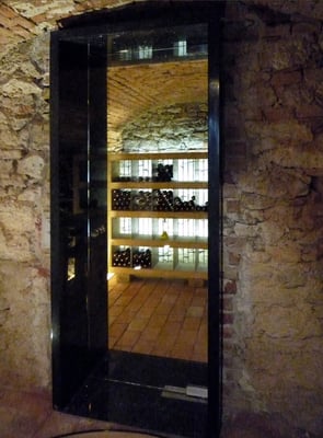 Weinregal hinterleuchtet aus Eichenholz massiv, Türgewände aus Naturstein - Foto © Knauer Architekten