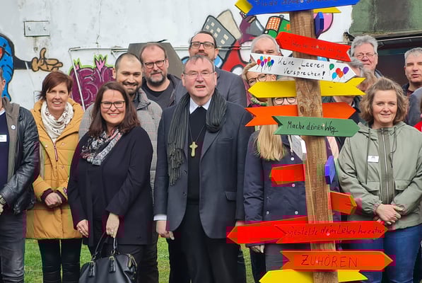 Vordergrund v.l.: Petra Keysers und Julia Schroeder (Caritas DU), Zhivko Slavev (Werkkiste), Stadtdechant (kom.)  Andreas Brocke, Weihbischof Ludger Schepers und Vanessa Glagau (Werkkiste) 