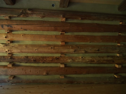 Strohlehm zwischen den altehrwürdigen Rundhölzern