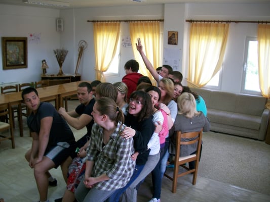 24 participants of the exchange trying to sit together on one chair