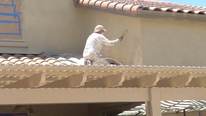 Spraying and backrolling the first coat of Ceramic InsulCoat Wall on Stucco.