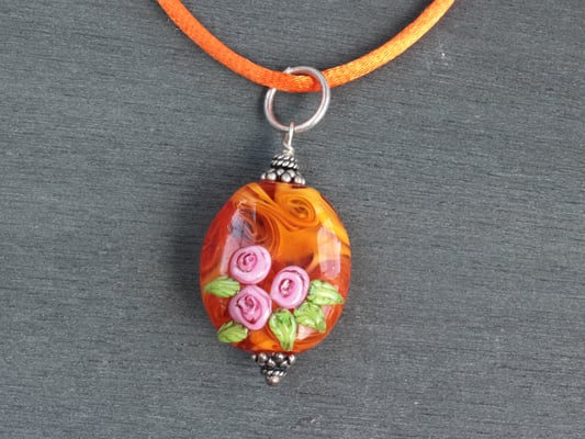 Anhänger in orange mit aufgesetzen Röschen