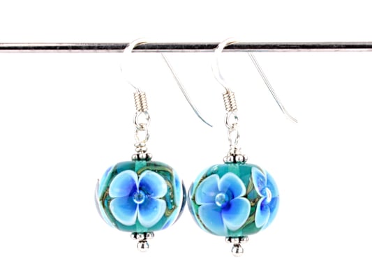 Ohrhänger Blütenzauber in Türkis auf grüntürkisem Hintergrund