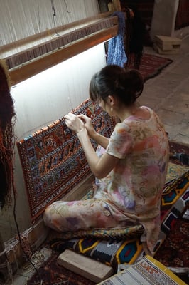 Teppichknüpferin in Bukhara - für das bereits geknüpfte Stück Teppich brauchte sie zwei Monate...