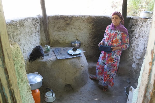 Abteilung "Warme Küche": Links köchelt die Fleischsuppe auf dem Gasbrenner vor sich hin, dann der Somsaofen, hinter der Köchin auf dem offenen Feuer die Pfanne mit Plov... - Es funktioniert!