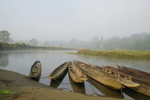 Die Kanus liegen am frühen Morgen auf dem stillen Wasser des Flusses...