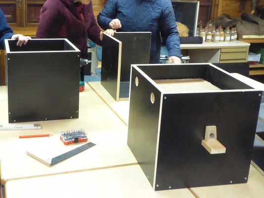 Vorne rechts ein bis auf das Dach fertiger Hummelnistkasten.