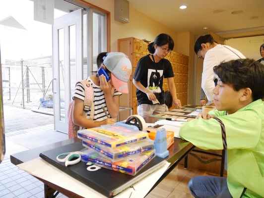 受付をする女の子。自宅の住所を忘れてしまい、お母さんに確認中です。