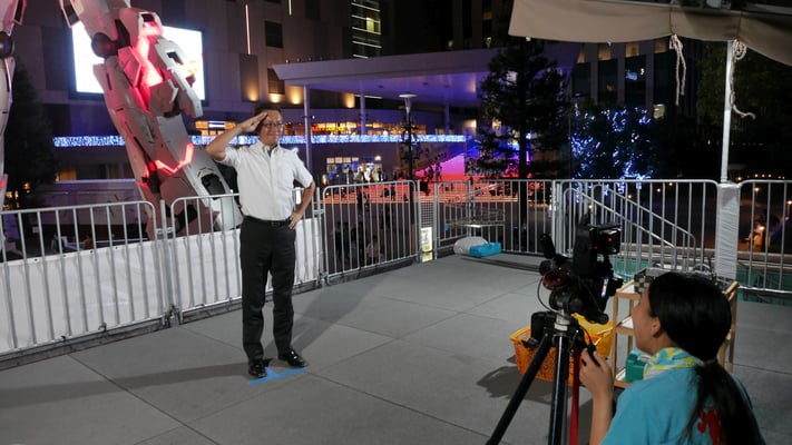 ガンダム前で撮影してもらう太田。