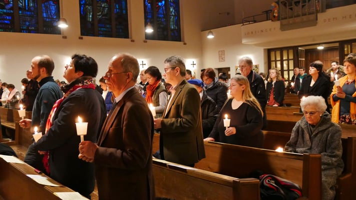 Auferstehungsfeier am Ostersonntag  um 5:00 Früh, leuchtende Osterkerzen in den Bänken