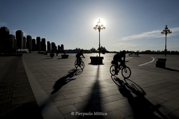 An empty square with two bikers in the new district of Kangbashi, Ordos