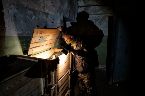 A tourist as he explores what's inside the crates, full of relics from the Soviet era