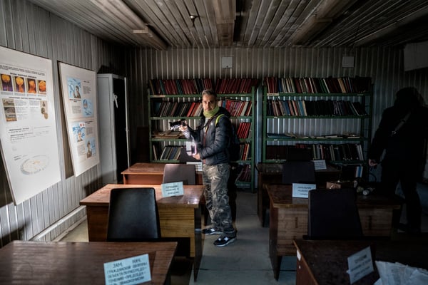 A tourist while taking pictures inside the bunker. In Soviet times this room was used for lectures on how to deal with a nuclear attack.