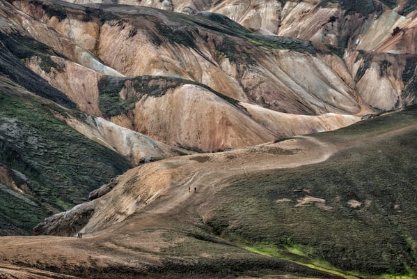 Iceland. Tourists begin the walk through the lava fields, starting from the Landmannalaugar base camp, in a volcanic region featuring coloured mountains and natural hot springs. The area is a popular tourist destination due to its geological formations