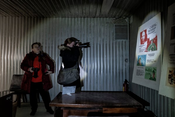 Tourists while taking pictures inside the bunker. In Soviet times this room was used for lectures on how to deal with a nuclear attack.