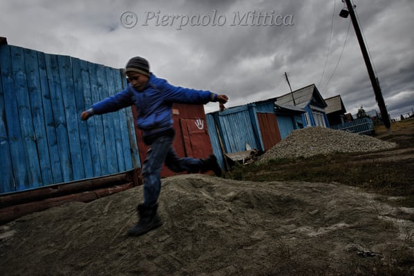 Child playing in the contaminated village of Karabolka