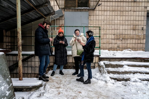 Kyiv residents at the entrance to the bunker looking for information on the internet about alarms. Inside the bunker there is no signal for mobile phones so in order to get information on the situation of air warnings and attacks by Russia