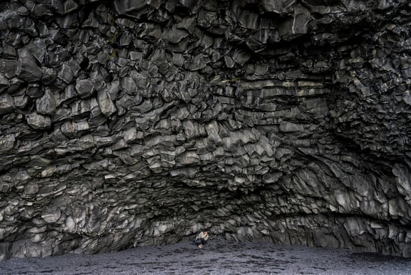 Iceland. A tourist visits a basalt cave on the black beach in Reynisfjara, one of the most picturesque places on the island.