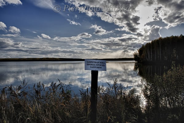 Contaminated lake used to discharge plutonium from the nuclear power plant. The sign warns: forbidden area, forbidden access. near Novogorny