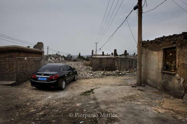 a fancy car in the semi-evacuated village of Qiabuqi