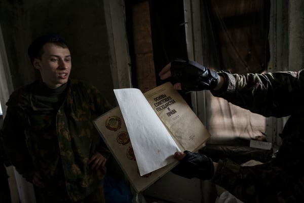 Maxim reading an old book from the Soviet era. Many stalkers come to Pripyat to read old books and magazines abandoned in apartments and schools