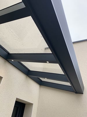 Auvent qui laisse passer la lumière du jour et qui s'éclaire la nuit avec des spots LED.