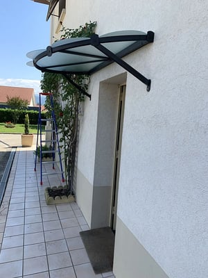 Marquise design, efficace et discrète pour une protection optimal de votre porte d'entrée.