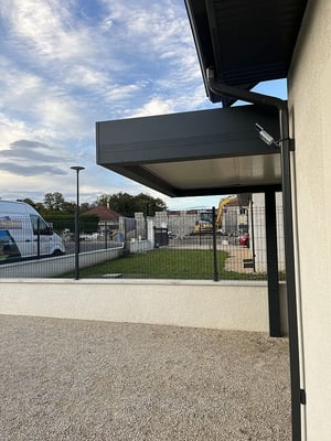 Carport en aluminium à toit plat et sur mesure. Auto-porté ou adossé avec des poteaux déportés.