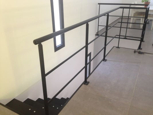 Rampe artisanale en fer forgé sur mesure pour escalier intérieur.