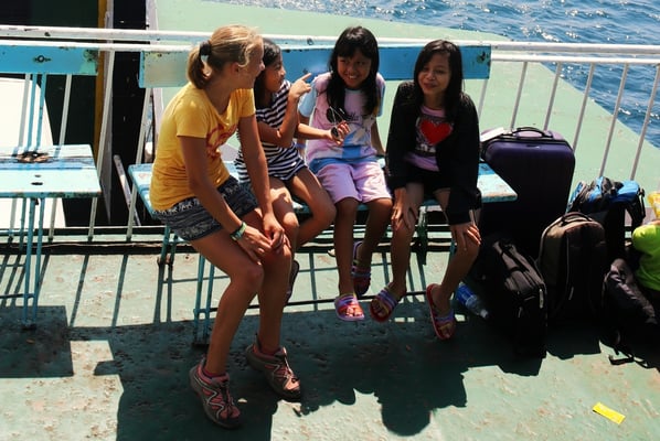 On the ferry to Bali: Adina is practising English conversation with local girls (one of them goes to the international school)