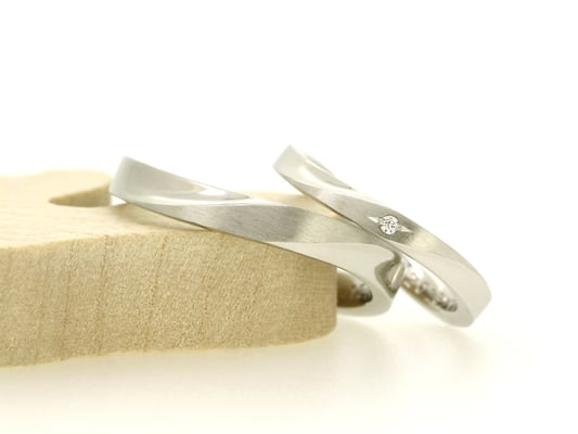 エッジを残した平板リングに傾斜をつけたデザイン。センターのみにヘアライン加工（つや消し）を。