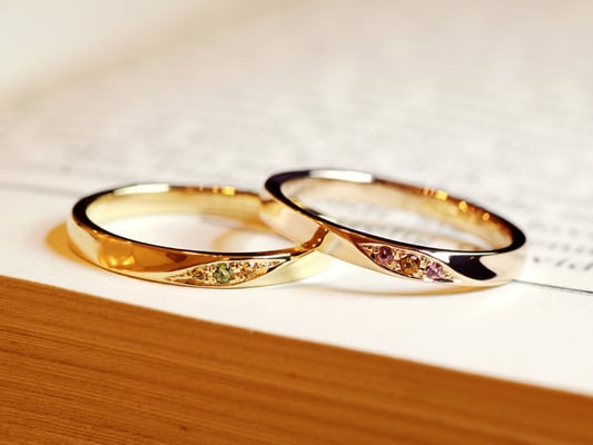 お2人のお誕生石であるトルマリン（グリーン・ピンク）、シトリン（オレンジ系の濃・淡）をそれぞれのリングに