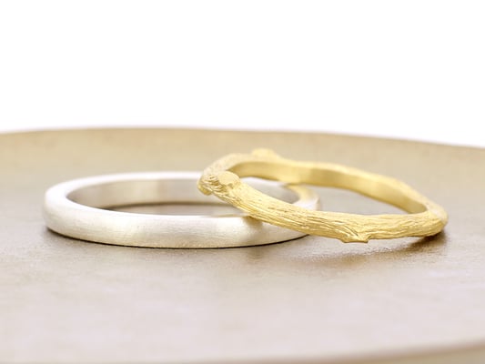 男性用リングはシンプルな甲丸タイプ、女性用リングは木の枝をイメージしたデザインに。