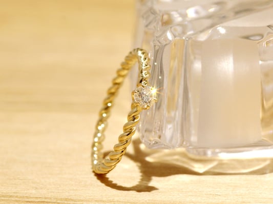 ゴールドの丸線をねじりダイヤモンドを添えた、細身リング。