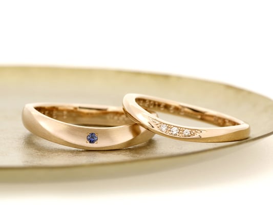 ゆるいU字のマリッジリング。男性用リングにはサファイア、女性用リングにはダイヤモンドを。