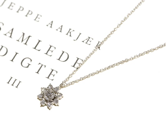 メインのダイヤモンドをメレダイヤで取り巻いたペンダント。